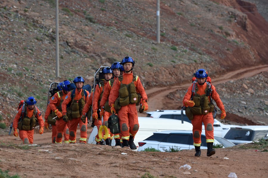 In this photo provided by China's Xinhua News Agency, rescuers walk into the accident site to search for survivors in Jingtai County of Baiyin City, northwest China's Gansu Province, Sunday, May 23, 2021.
