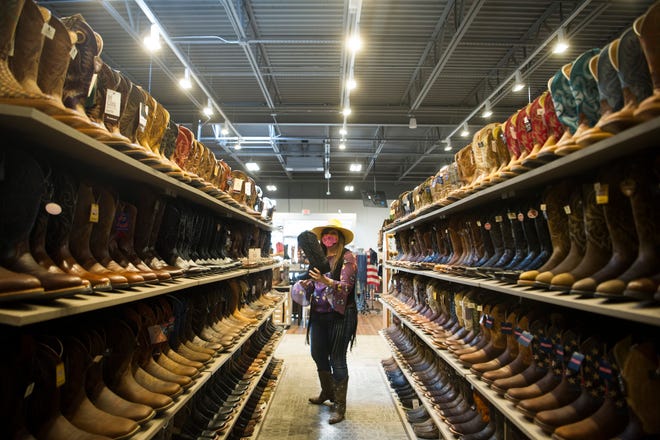 Store manager Bridgette Detienne grabs a boot off a shelf at Boot Barn, located at 112 Walker Springs Road in West Knoxville, Friday, May 21, 2021. Boot Barn, which operates over 250 locations in 30 states, opened its newest Knoxville location in March.