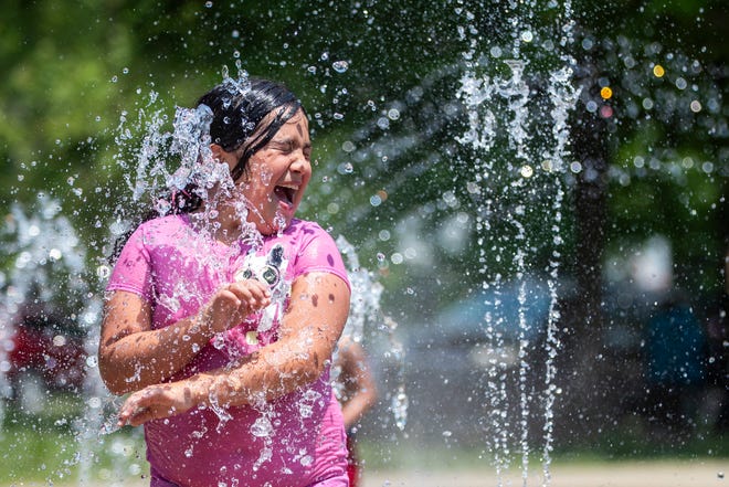 Amalia Trejo, 9, plays in the spray area at Iroquois Park on Monday as families came out to beat the heat.  May 24, 2021