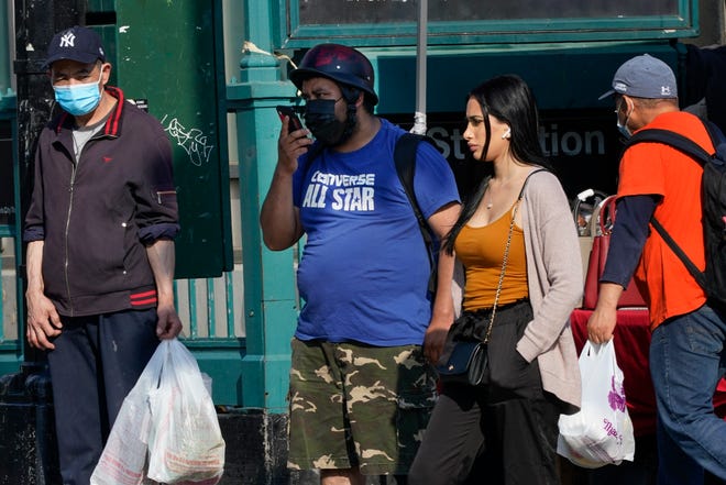 Pedestrians wear protective masks during the coronavirus pandemic Wednesday, May 19, 2021, in the Queens borough of New York. New York eased its mask and social distancing mandates again Wednesday, however, masks are still required for everyone in many settings. (AP Photo/Frank Franklin II)