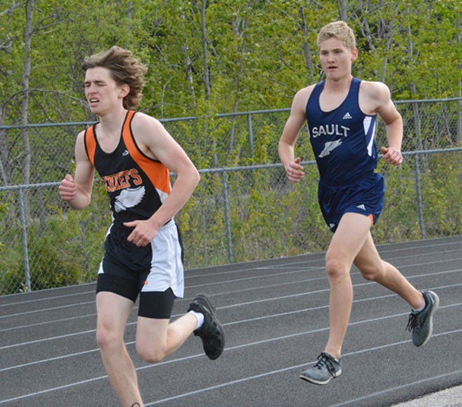 Cheboygan's Luke Patrick, left, runs the 3200 while Sault Ste. Marie's Hadyn Jones looks to pass during the Straits Area Conference track and field championship meet in Sault Ste. Marie on Monday.