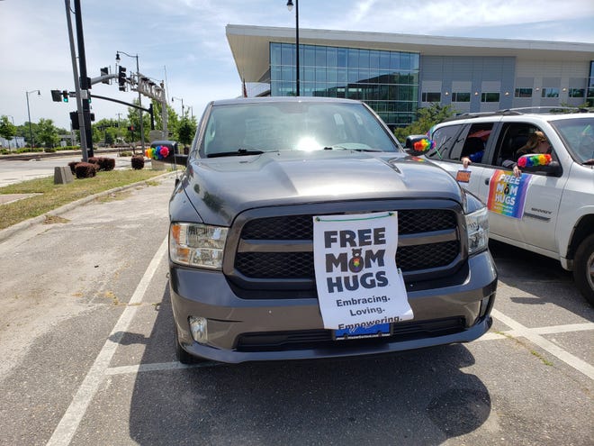 Community members gather to join a mobile car parade organized by the Fayetteville chapter of Free Mom Hugs.