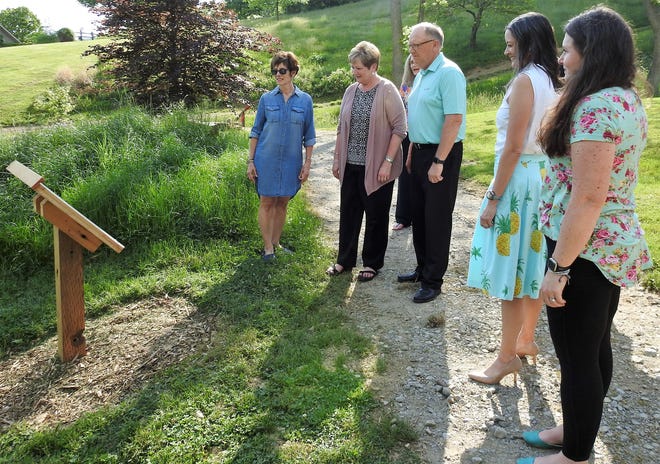 Tina Stoffer of the Clary Gardens Board, Kelly Kendall and Steve Nelson of Frontier Power, library Director Jennifer Austin and Clary Garden Director Jandi Adams read one of the pages on a post part of the new StoryWalk at Clary Gardens. The project was a collaboration of the Gardens, library and Frontier Power. Families can walk a path and read a story on 18 posts that will change with the seasons.