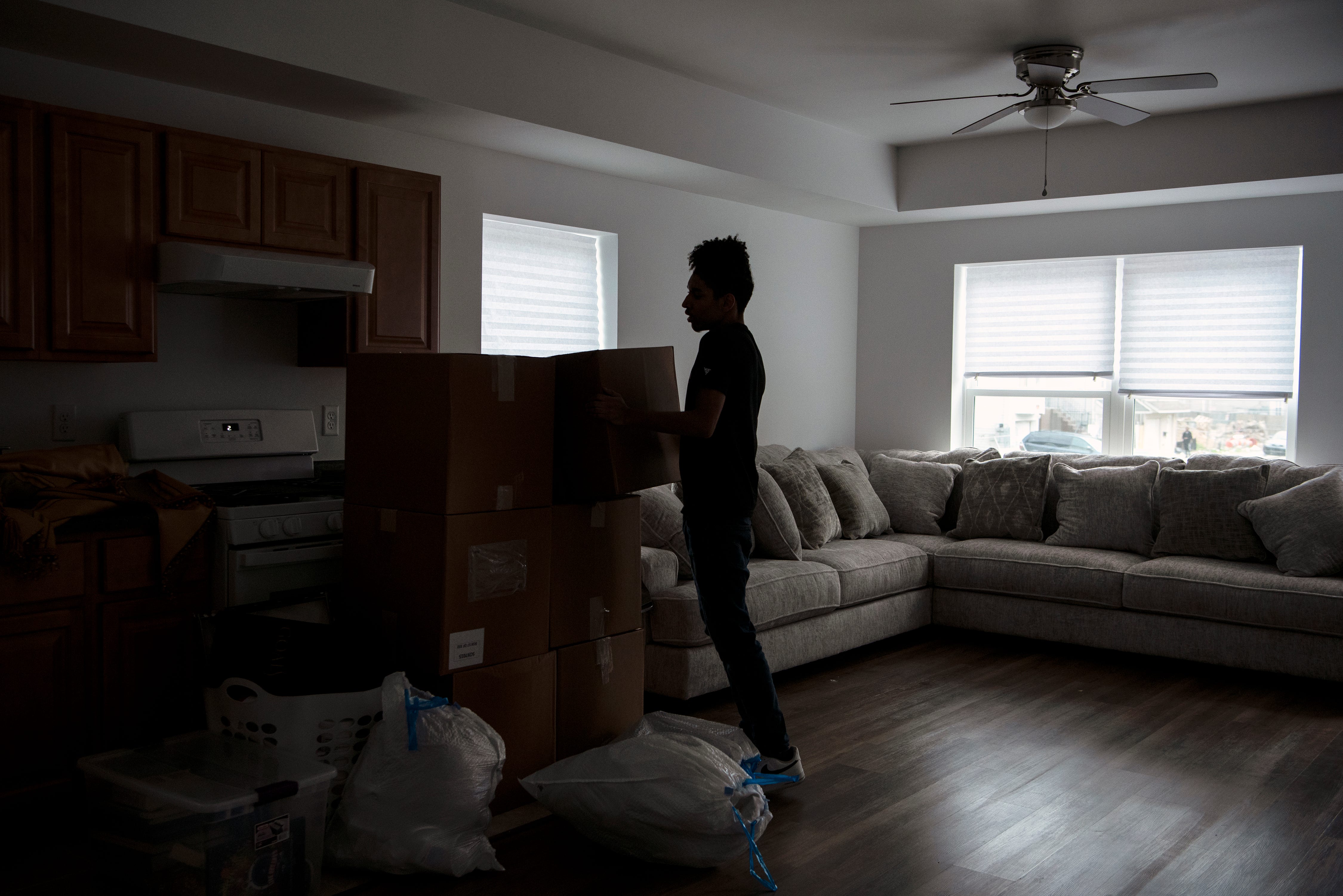 Carlos De Los Santos, 17, is excited to have his own bedroom for the first time in his life. Here, he helps unpack as his family start a new life in a Paterson Habitat for Humanity home on Hamilton Avenue.