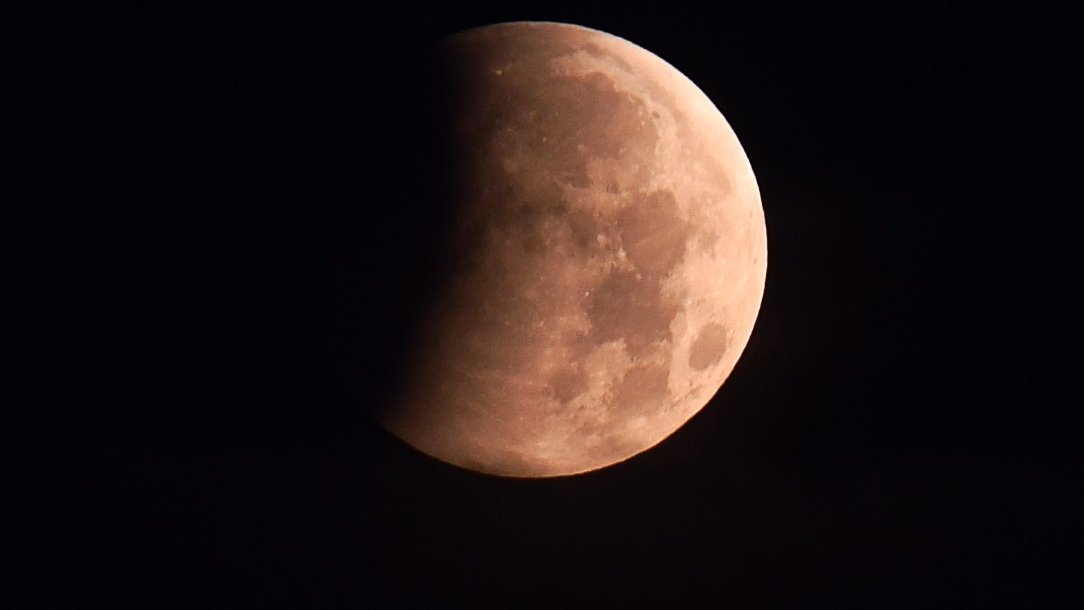 Un eclipse lunar parcial sobre el río Banana en el sur de Cocoa Beach, Florida, al amanecer.