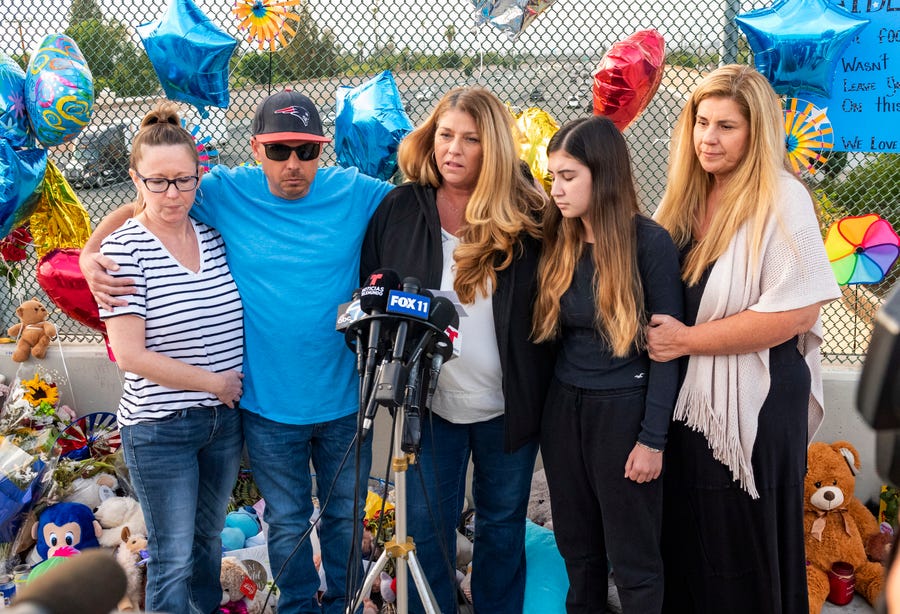 Family members of 6-year-old Aiden Leos stand at a makeshift memorial Tuesday on the Walnut Avenue overpass at the 55 Freeway in Orange, Calif.