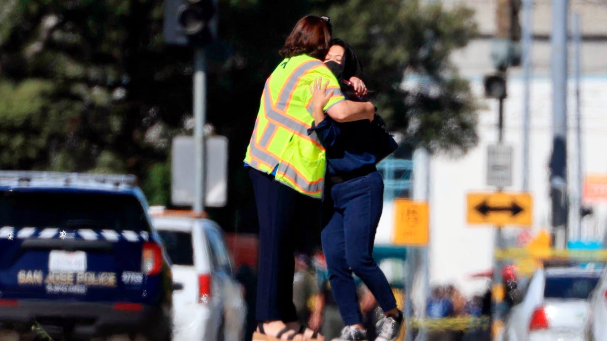 Two people are pictured hugging on Wednesday near the shooting scene in San Jose, California. According to authorities, an employee opened fire at a railyard serving Silicon Valley, killing multiple people before taking his own life.