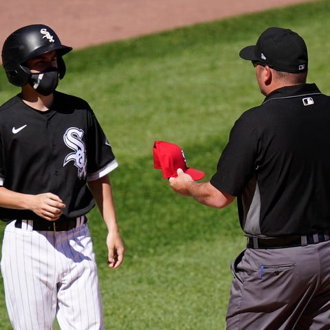 Second base umpire Dan Bellino gives a confiscated