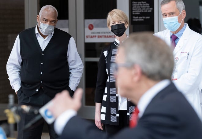 Ohio State athletic diretor Gene Smith, president Kristina Johnson and Wexner Medical Center CEO Harold Paz listen to Gov. Mike DeWine speak after he toured the COVID-19 mass vaccination facility set up at Ohio State's Schottenstein Center on March 9.
