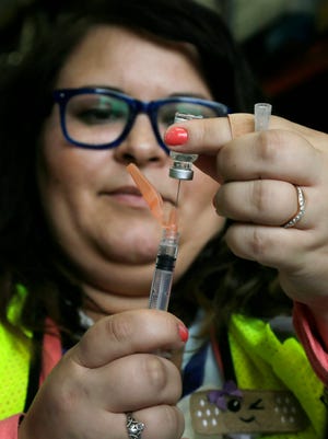 Erin Kelley, RN, measures a dose of the Johnson & Johnson COVID vaccine during a walk-in clinic hosted by the Delaware Public Health District.