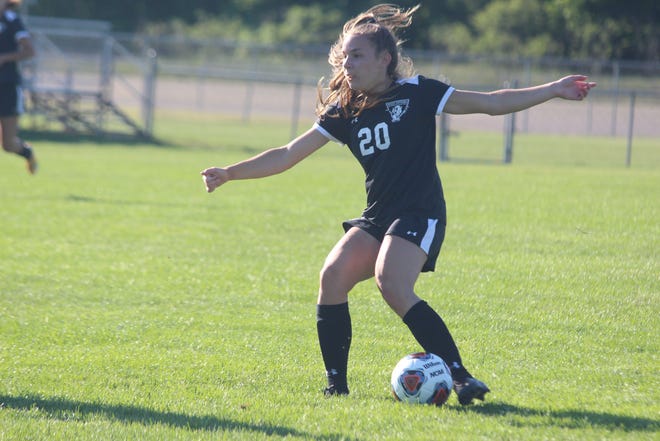 West Ottawa junior Molly Borski fires the ball at the net during their district playoff game