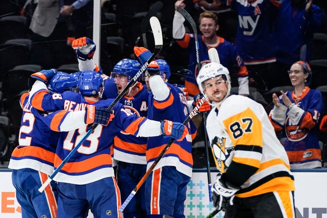 New York Islanders' Brock Nelson celebrates with teammates after scoring a goal as Pittsburgh Penguins' Sidney Crosby (87) skates past them during the second period of Game 6.