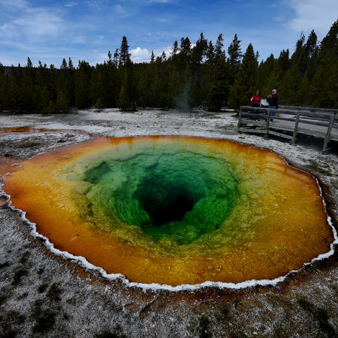 Tourists view the Morning Glory hot spring in the 