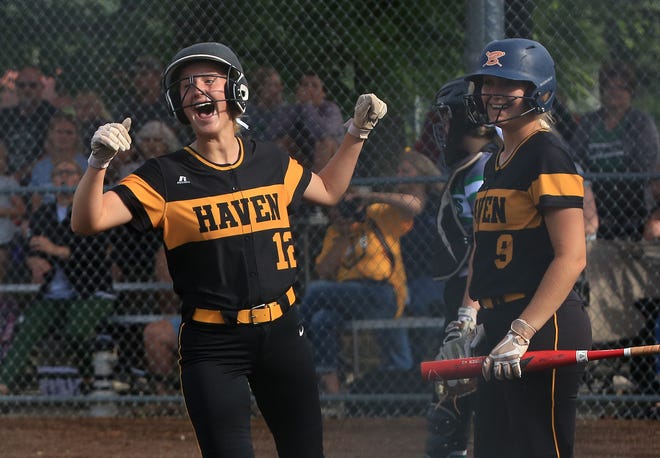 Haven's Brooke Brawner (12) celebrates coming home to score with teammate Amie Yoder (9) during their Class 3A quarterfinal softball game against Prairie View in Manhattan Friday. Haven defeated Prairie View 6-0. 
