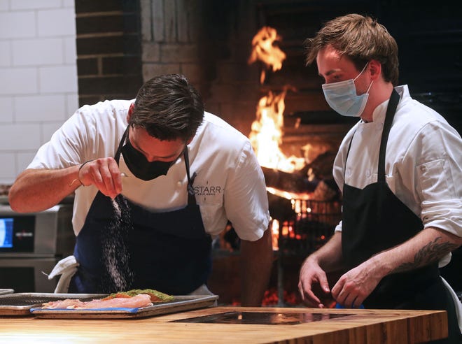Kyle Knall, left, seasons food during preparation, while cook Sam Galaszewski watches on May 27 at the soft opening of Birch at 459 E. Pleasant St. in Milwaukee.