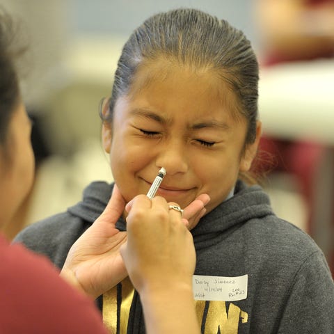 Daisy Jimenez reacts as she gets FluMist Influenza