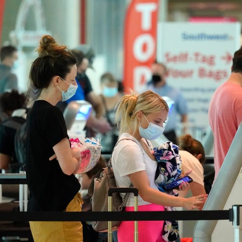 Travelers check in at Love Field airport Friday, M