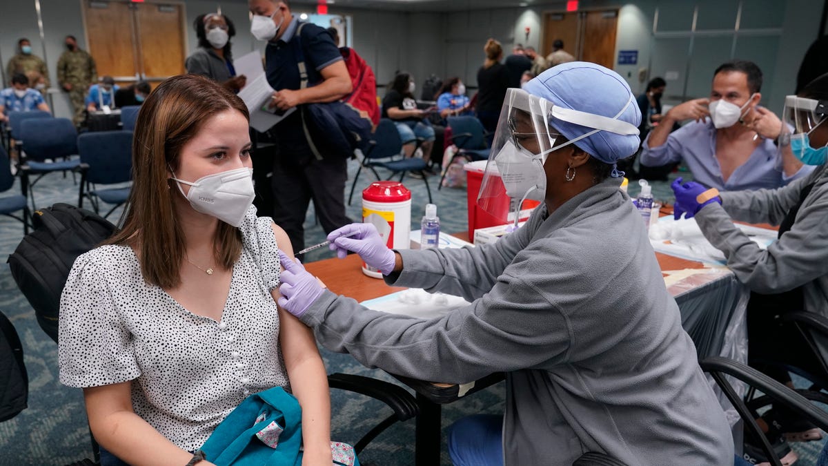 Natalia Dubom, of Honduras, gets the Johnson & Johnson COVID-19 vaccine on Friday at Miami International Airport. The vaccine will be offered to all arriving passengers through Sunday as part of a Florida Emergency Management Agency program.