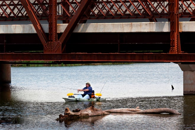 A person fishes from a kayak under the Route 66 bridge at Lake Overholser in Oklahoma City last summer. Oklahoma's free fishing days are June 5-6.