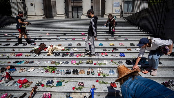People place 215 pairs of children's shoes on the 