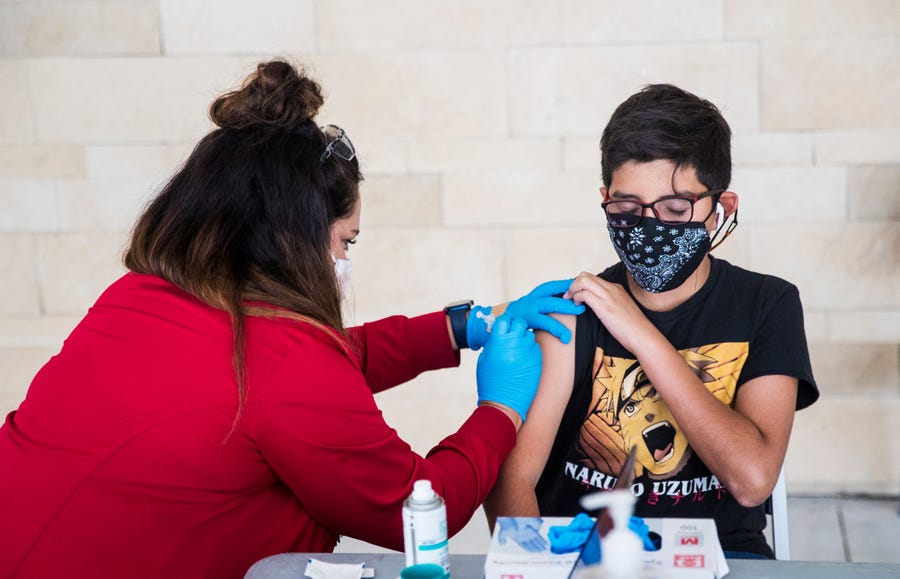 Nurse Courtney Cherco gives Marco Tapia, 13, a Pfizer COVID-19 vaccine at a mobile clinic at Family Health Centers in Lehigh Acres, Fla., on May, 27.  Golisano Children's Hospital launched the clinic for kids.