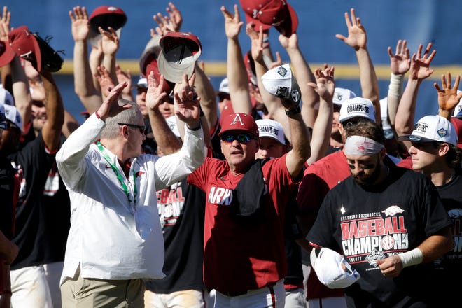 Arkansas coach Dave Van Horn, center, celebrates with the team after defeating Tennessee in an NCAA college baseball championship game during the Southeastern Conference tournament Sunday, May 30, 2021, in Hoover, Ala.