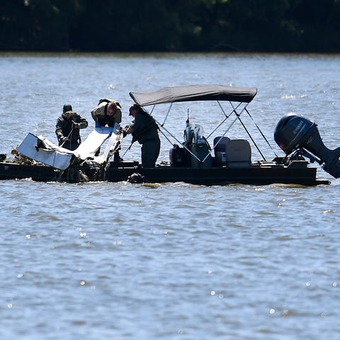 Emergency personnel remove debris of a plane crash