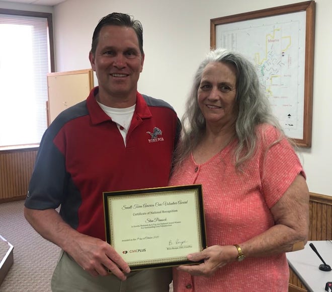 Minerva Local Schools' Superintendent Gary Chaddock presents the Small Town America Civic Volunteer Award to Karen Pennock, on behalf of her husband, Stan.