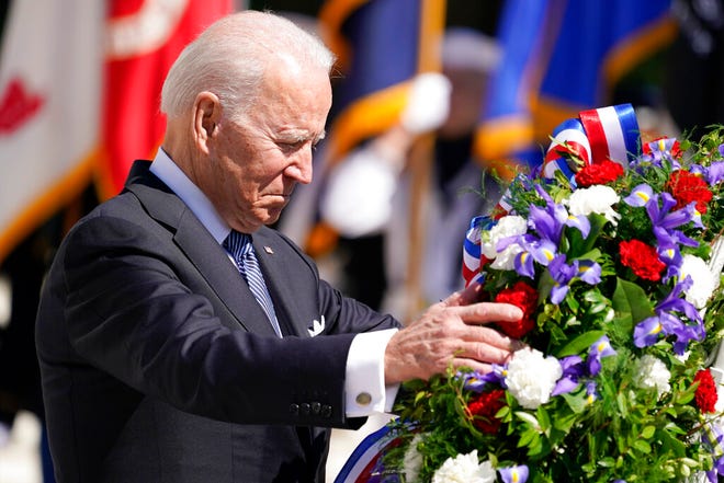 President Joe Biden adjusts a the wreath at the Tomb of the Unknown Soldier at Arlington National Cemetery on Memorial Day, Monday, May 31, 2021, in Arlington, Va.(AP Photo/Alex Brandon)