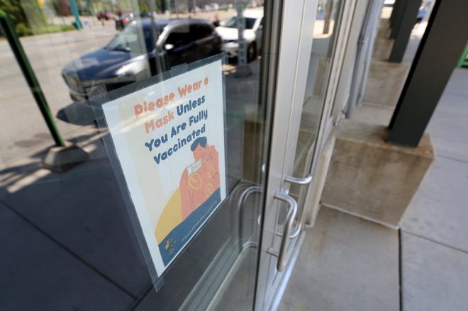 A sign advises unvaccinated customers to wear a mask at the Public Market on North Water Street in Milwaukee on Tuesday, June 1, 2021.