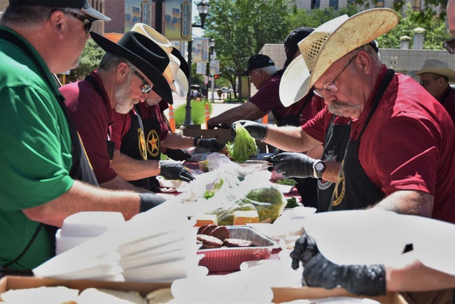 Coors Cowboy Club'ın ekibi, bu dosya fotoğrafındaki meydanda High Noon'da servis yapmak için çizburgerler hazırlıyor.