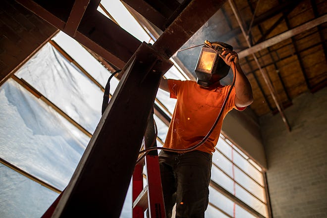 An employee of Tri-City Ironworks of Davenport, Iowa, does some welding near the Roland Hegg Auditorium inside Galesburg High School as construction work continues on Thursday, June 3, 2021.
