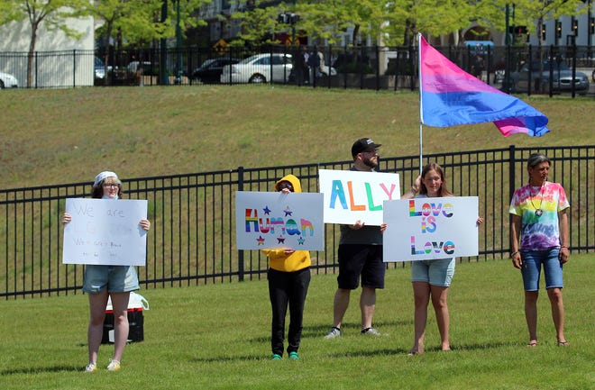 A group of people wave flags and signs in support of Pride Month during a supportive rally on the corner of East Mitchell and U.S. 31 on Wednesday, June 2.