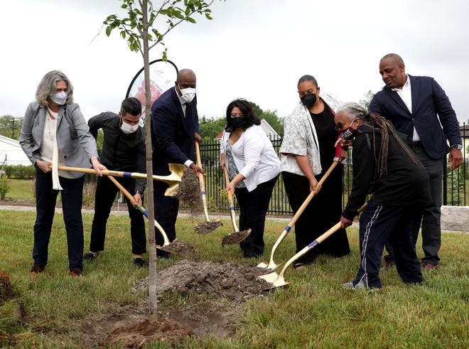 (L to R) Margaret O'Gorman, president of Wildlife Habitat Council, Joshua Rubin, president of MI Rain Barrel, Joe Tate, a member of the Michigan House of Representatives from the second district, Monica Tabares, Vice President of the Greening of Detroit, Valencia Mobley, deputy director of Detroit Water and Sewage, Ron Stallworth, the external affairs lead for Wayne County, Stellantis - North America and Stephanie Broddie, a school teacher at Southeastern High School ceremoniously add dirt to a tree after the Stellantis press conference and ground breaking at the corner of Kercheval and Beniteau in Detroit for the $1 million green initiative and education pavilion at Stormwater Park on Thursday, June 3, 2021.