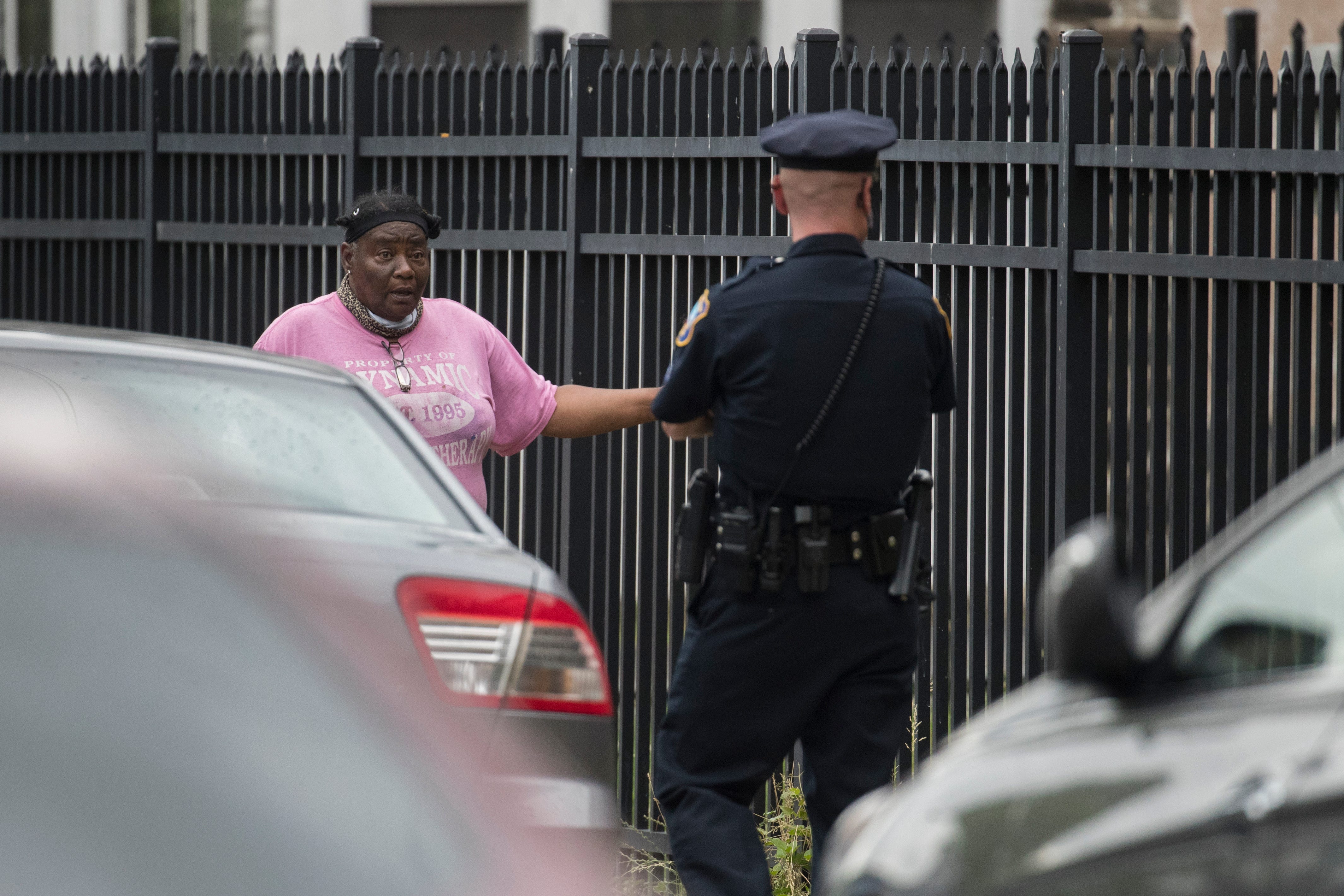 A Wilmington Police officer speaks to a resident asking to be let back into her apartment after three Wilmington Police officers were shot in the 2400 block of Market Street Thursday, June 3, 2021. Local residents were locked down outside for up to 12 hours. 