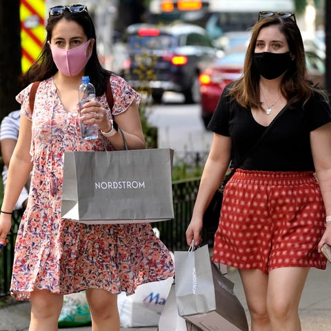 Shoppers carry their bags as they walk along a sho