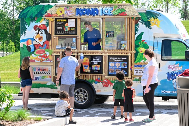 Customers line up at the Kona Ice truck for a cool treat during Friday's Food Truck Friday at Switchyard Park.