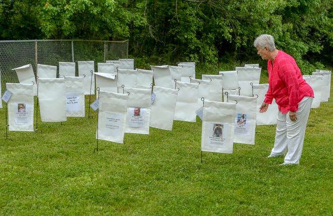 Gerry Grabowski looks over the display, which commemorates the 81 North Kingstown residents who have died of COVID-19.