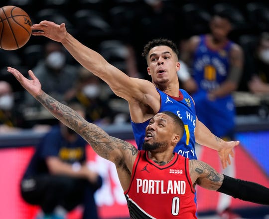 Portland Trail Blazers guard Damian Lillard (0) goes up for a shot against Denver Nuggets forward Michael Porter Jr. (1) in the second half of Game 1 of a first-round NBA basketball playoff series Saturday, May 22, 2021, in Denver. (AP Photo/Jack Dempsey).