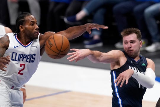 Los Angeles Clippers forward Kawhi Leonard (2) defends as Dallas Mavericks guard Luka Doncic, right, makes a pass in the second half in Game 3 of an NBA basketball first-round playoff series in Dallas, Friday, May 28, 2021. (AP Photo/Tony Gutierrez).