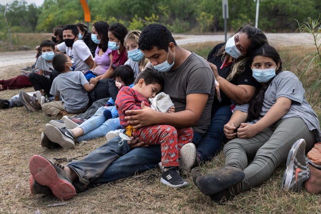 A Guatemalan family waits with fellow immigrants to board a U.S. Customs and Border Protection bus to a processing center after crossing the border from Mexico on April 13 in La Joya, Texas.