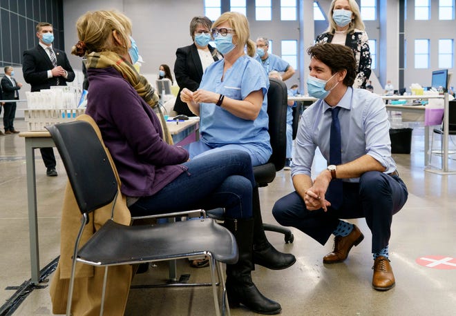 Canadian Prime Minister Justin Trudeau, right, has said he prefers to wait until 75% of Canadians are vaccinated before opening the border. He suspects that will happen this fall.