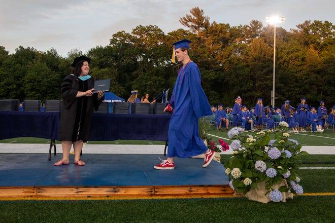 Students walk in front of peers and family members to receive their diploma at Scituate high school on Friday June 4, 2021. Photo by Lauren Owens Lambert / The Patriot Ledger.