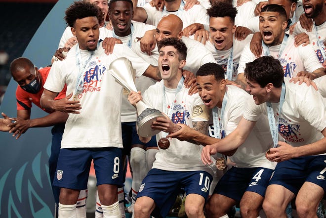 Christian Pulisic lifts the Concacaf Nations League trophy with teammates after defeating Mexico in the final at Empower Field at Mile High.