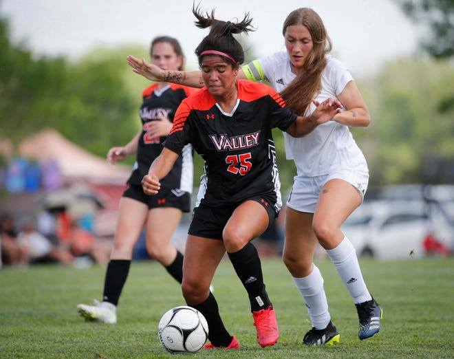 Valley junior defender Ana Spaine, left, moves the ball away from Ankeny Centennial's Meghan White in the first half of a 2021 match.