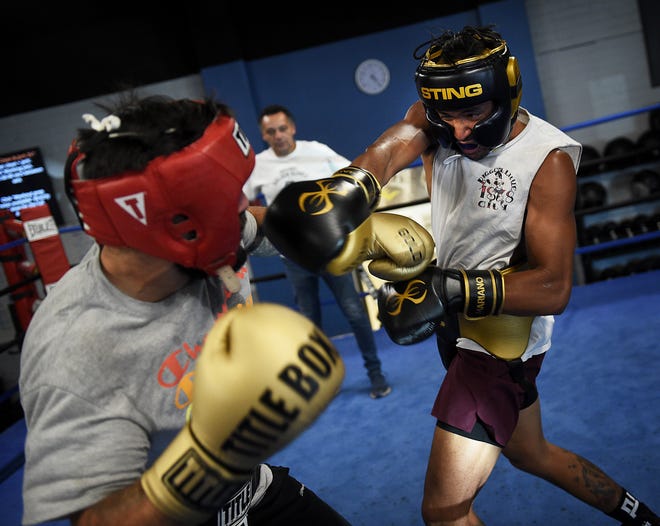 Local boxer J.J. Mariano, right, spars with Rafael Garcia under the watchful eyes of his trainer Pat Jefferson at Elite Boxing & Crossfit in Reno on June 8, 2021.