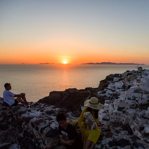 People took in the sunset in the town of Oia on th
