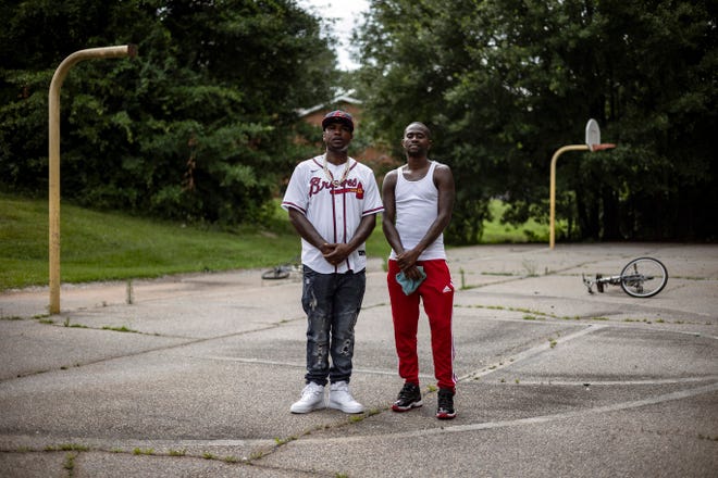 Darius Brightwell (left) and Petier Davis, founders of the nonprofit Save the Youth, stand on the old basketball court that was part of the former Nellie B Library. The library, which served as a community center, closed several years ago, but Brightwell and Davis are advocating for it to be repaired and reopened.