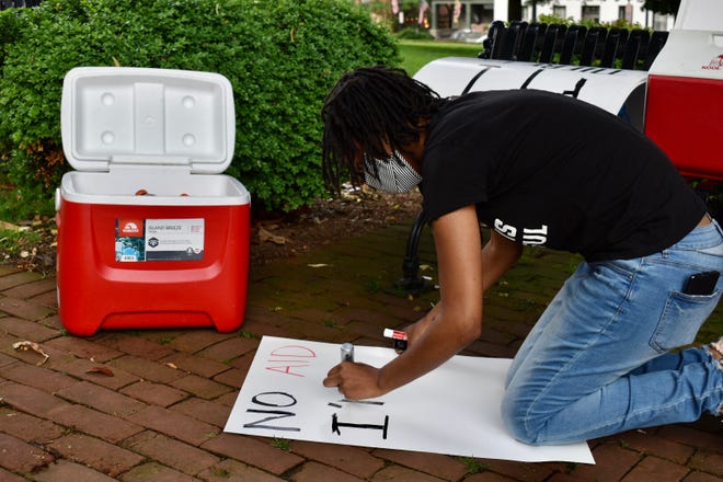 Jahmilla Fisher, 25, of Germantown, makes a poster for a small protest in Annapolis on June 9.