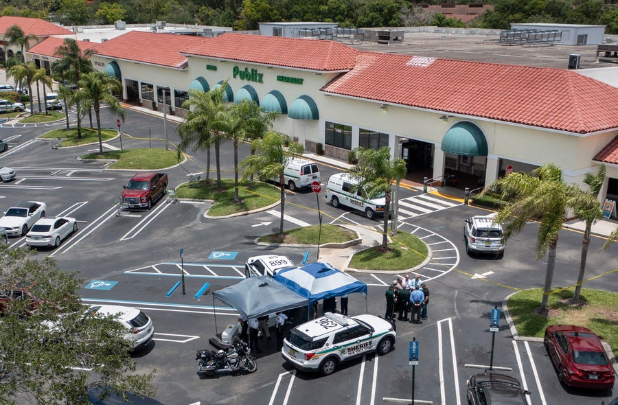Police gather at a Publix shopping center where police say three people were shot and killed in Royal Palm Beach, Fla., on June 10.